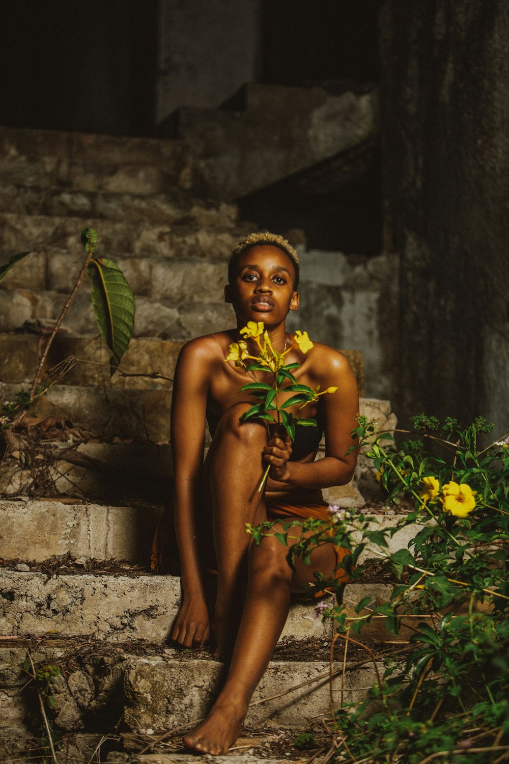 a woman sitting on steps with a flower in her hand