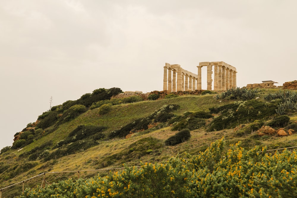 a large stone structure sitting on top of a lush green hillside