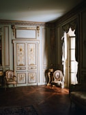 A spacious suite featuring large windows and opulent decor.