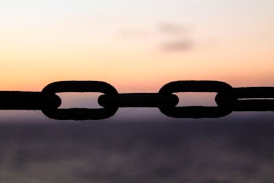 A symbolic chain breaking apart against a bright sky, representing freedom from obligation.