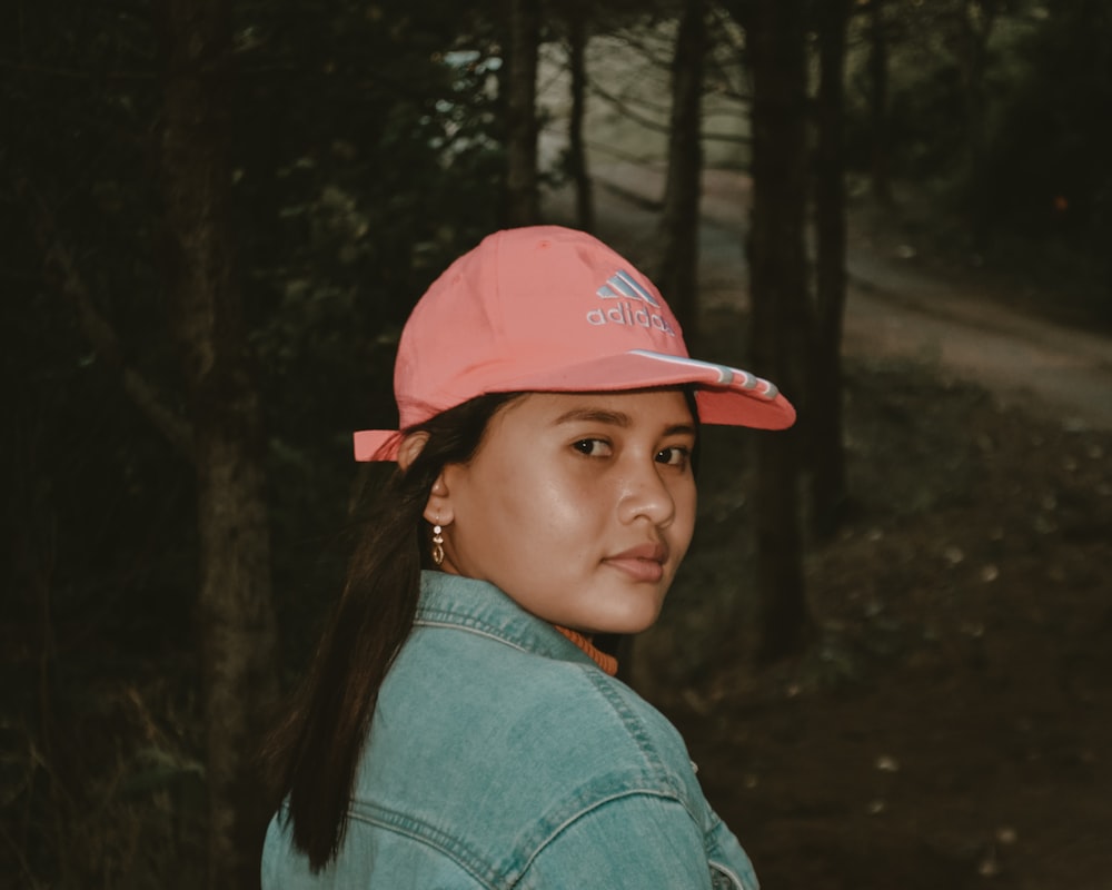 a woman wearing a pink hat in the woods