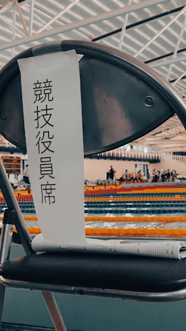 A xteam water polo goal folded and ready for easy transport beside a poolside bench.