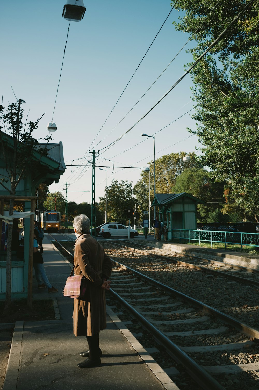 an old woman standing on a train station platform