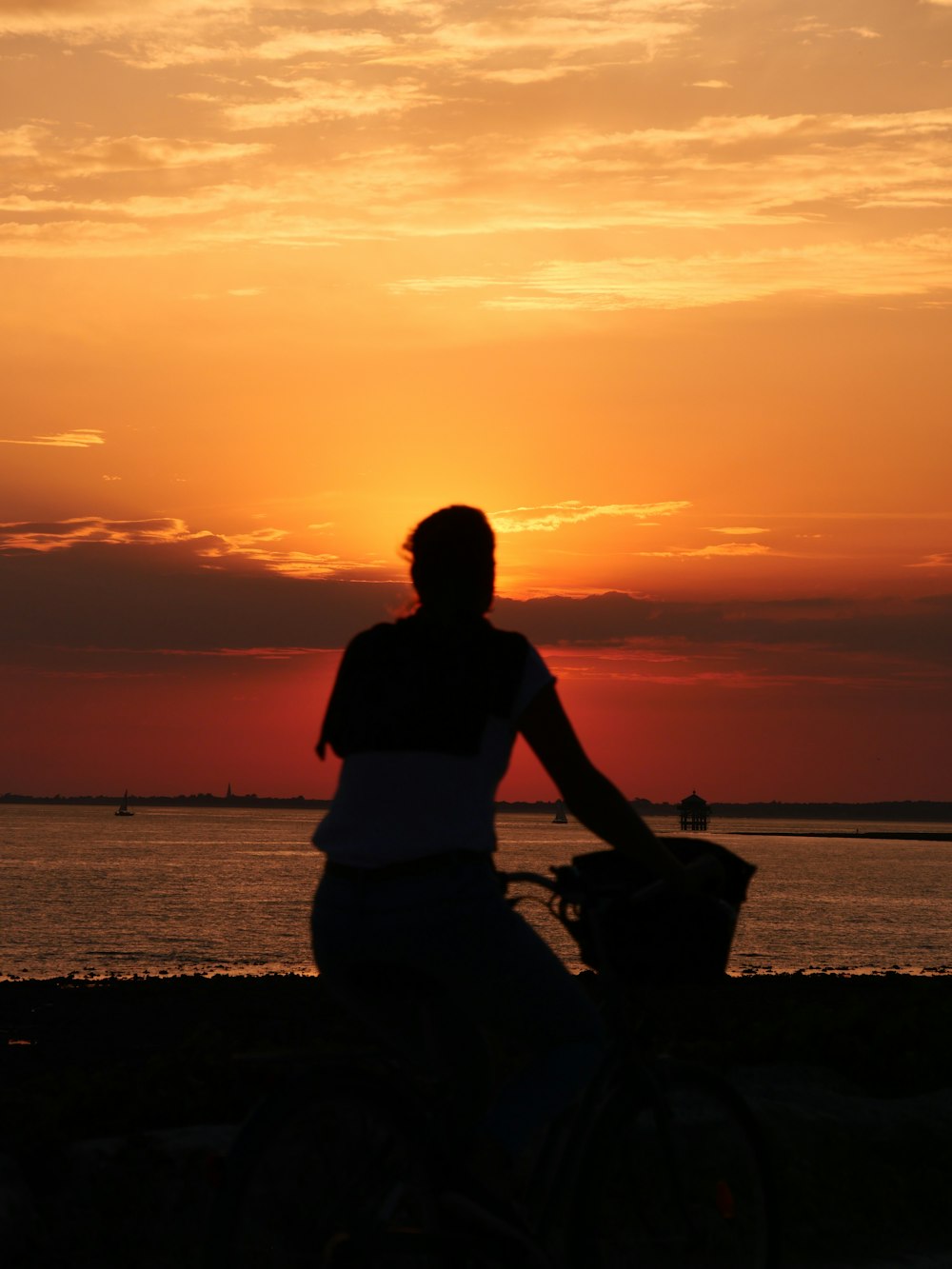 une personne à vélo sur une plage au coucher du soleil