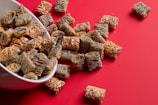 a bowl full of dog treats on a red surface