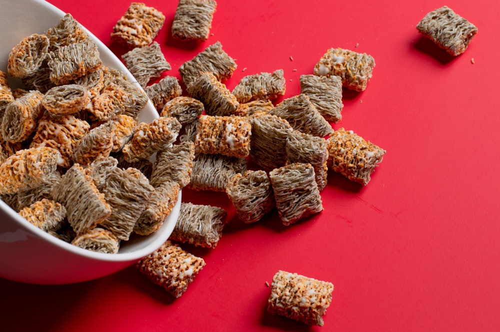 a bowl full of dog treats on a red surface