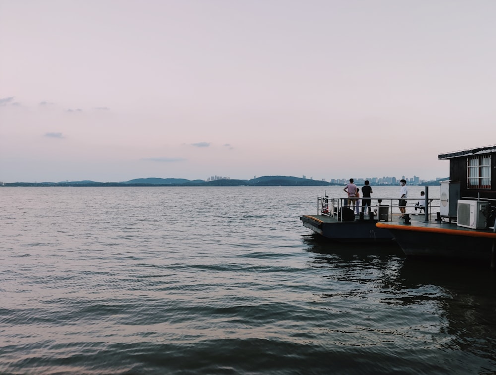 a boat with people standing on it in the water