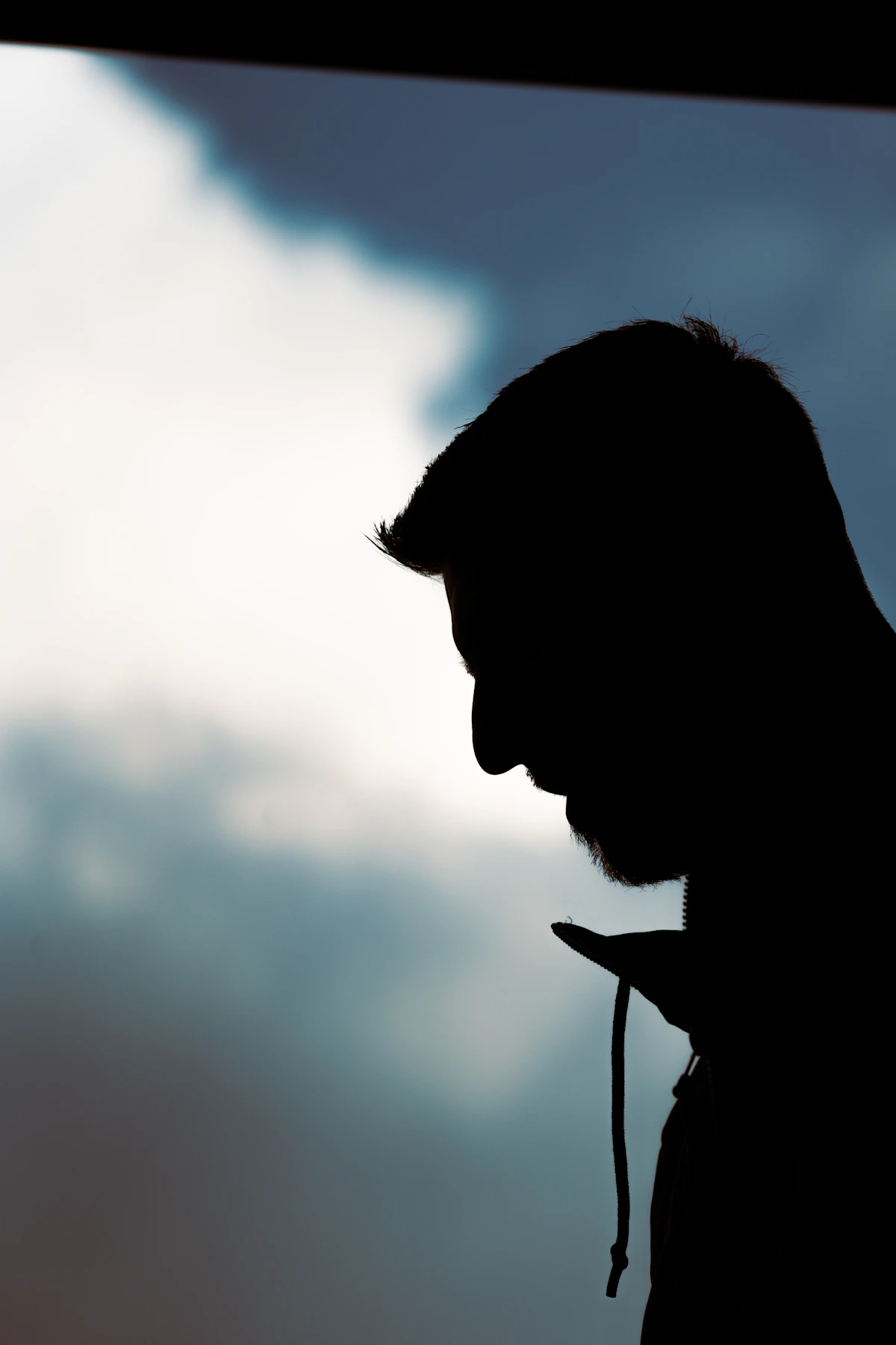 Ilustrasi siluet orang memegang smartphone, simbol kewaspadaan terhadap penipuan link palsu