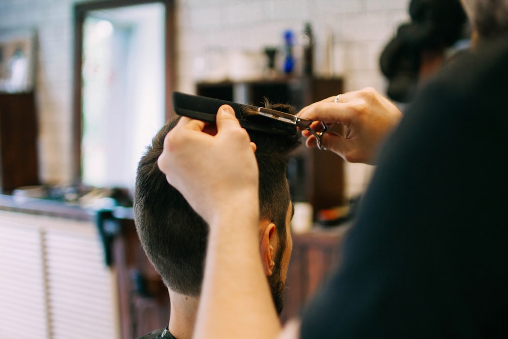 a man cutting another mans hair in a barber shop