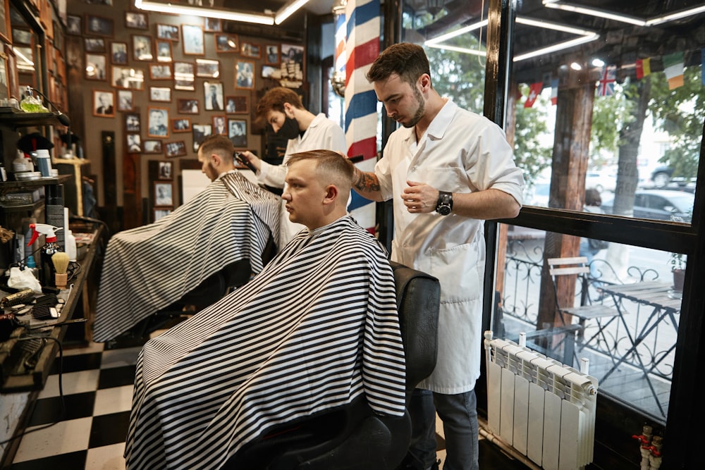 a barber cutting a man's hair in a barber shop
