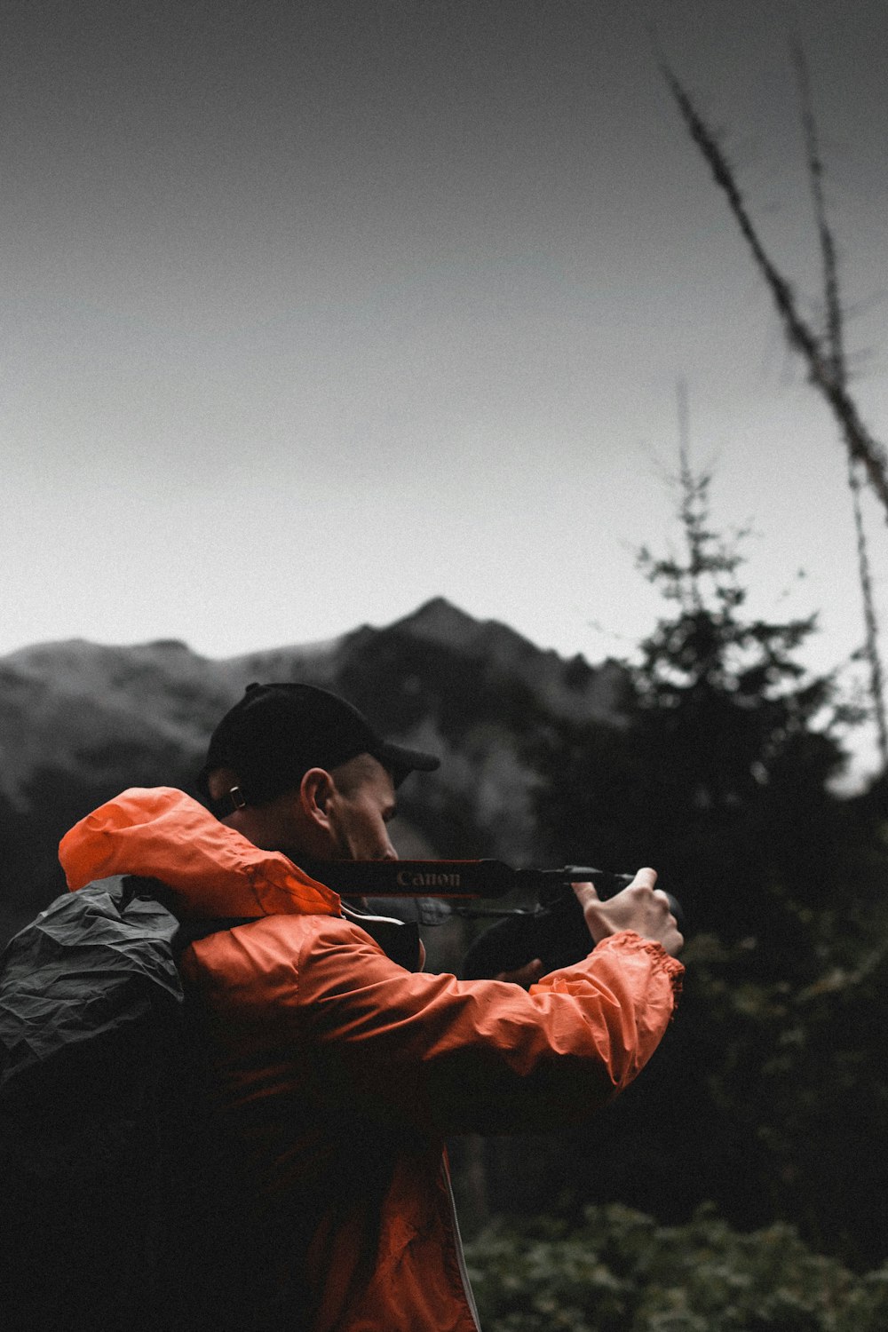 a man in an orange jacket holding a gun
