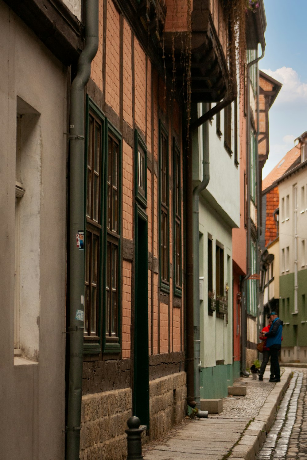 a person is walking down a cobblestone street