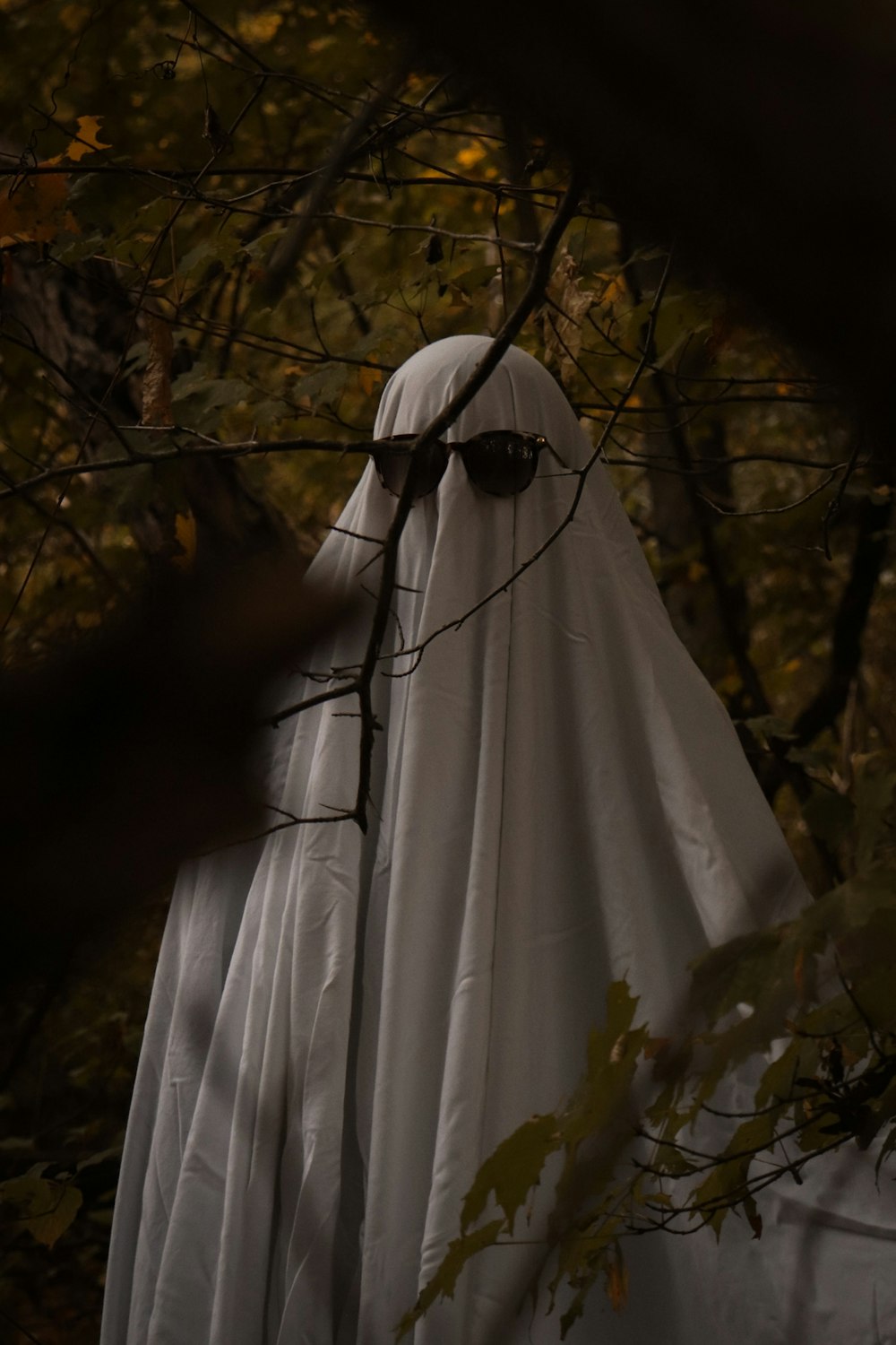 a ghostly person wearing sunglasses and a white cloak