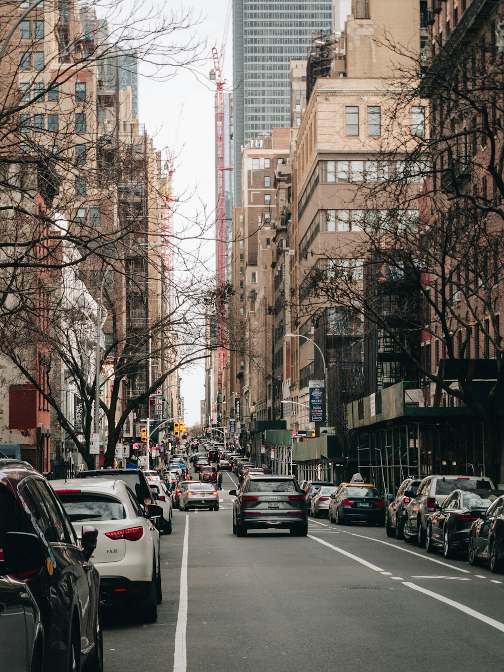 a street filled with lots of traffic next to tall buildings