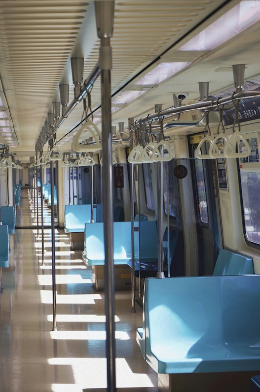 台北捷運車廂內部，藍色座椅與拉環