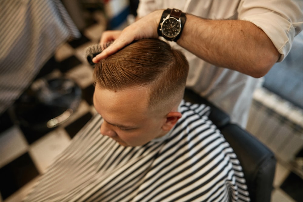 a man getting his hair cut at a barber shop