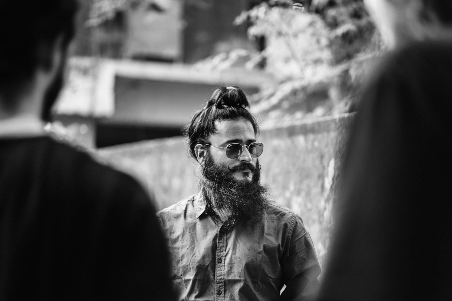Tomasz Byk, bearded and in glasses, standing against a wall outside the hall