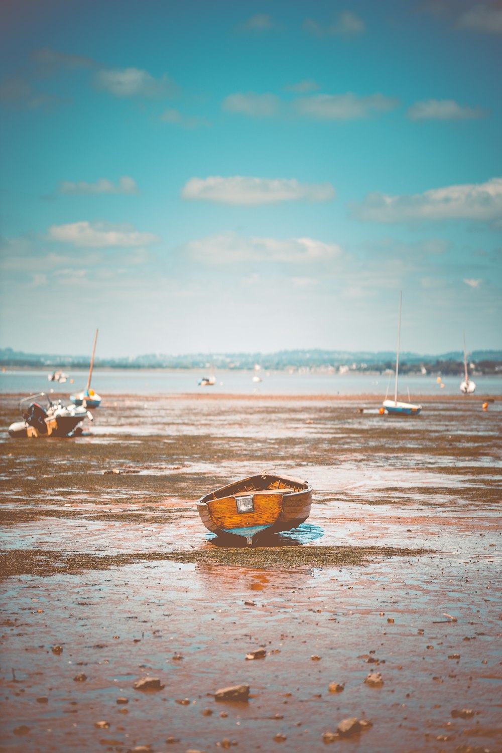 Un petit bateau assis au sommet d’une plage de sable