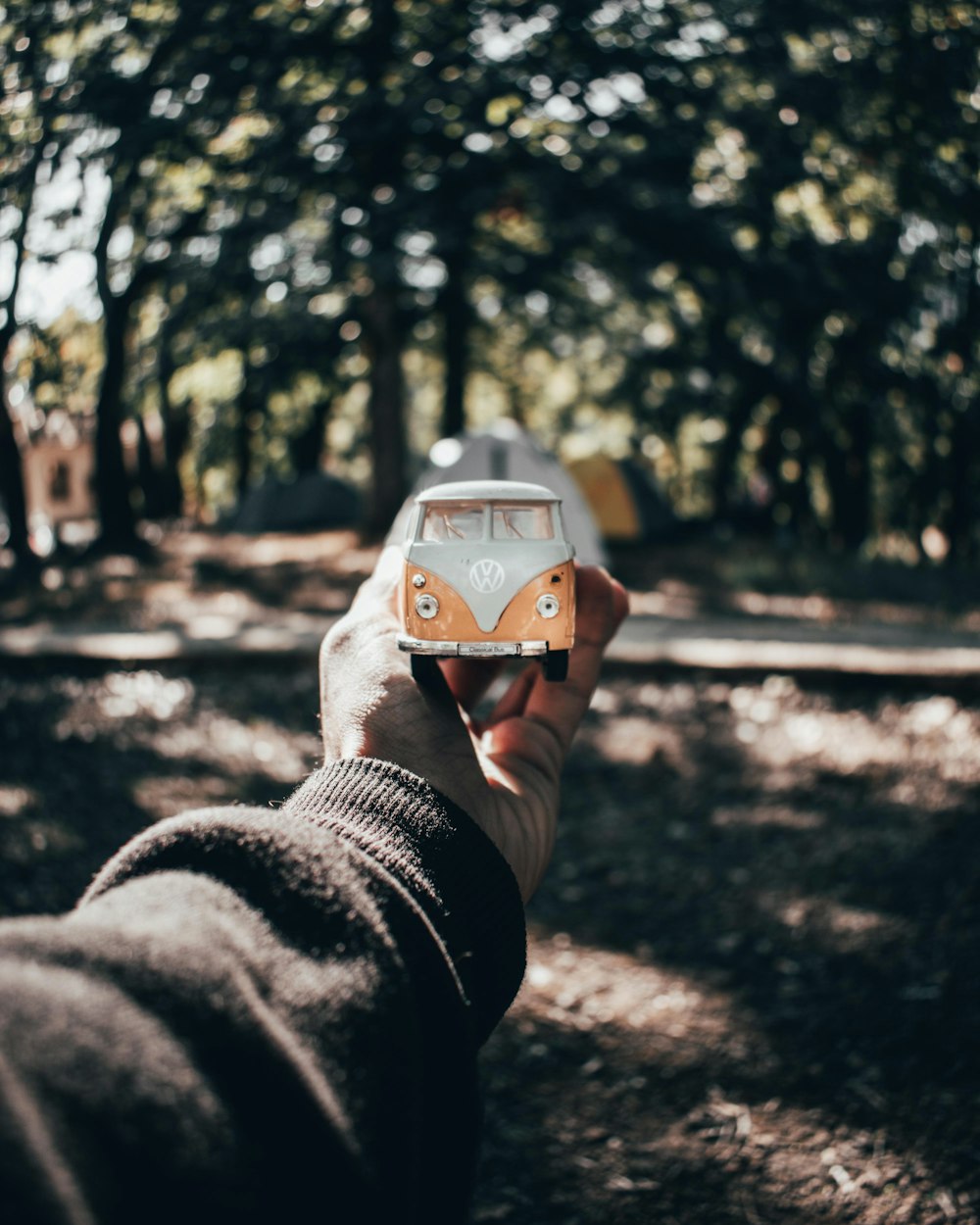 a person holding a small toy car in their hand