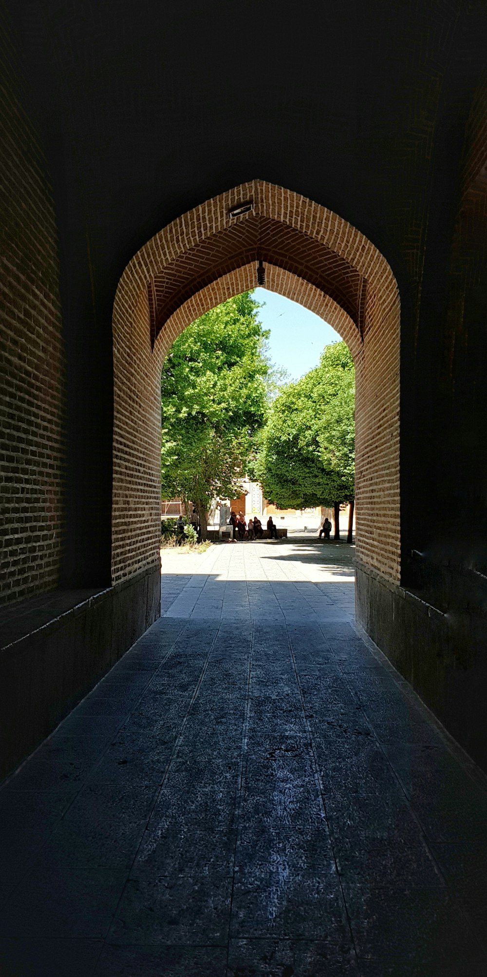 a view of a walkway through a brick tunnel