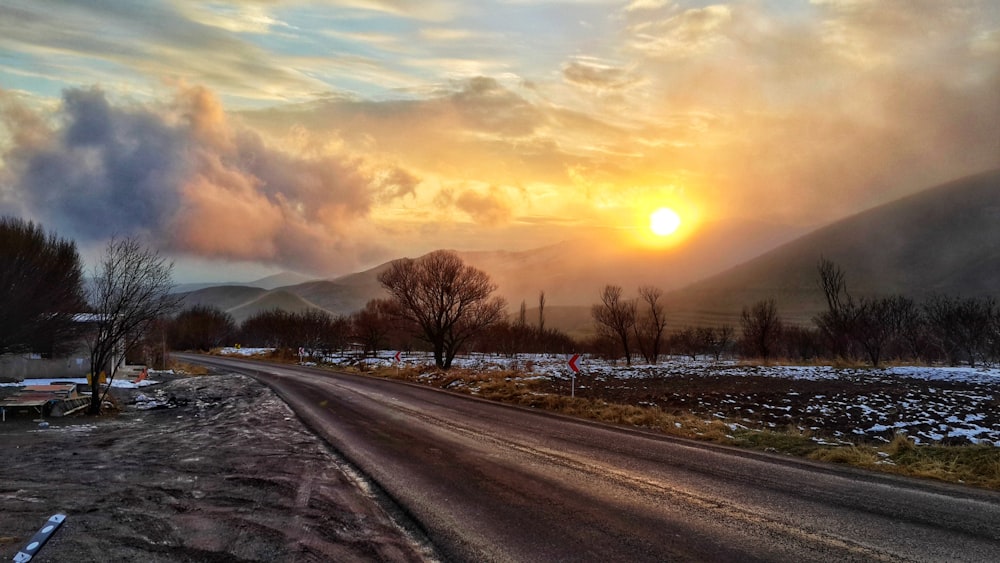 the sun is setting over the mountains in the distance