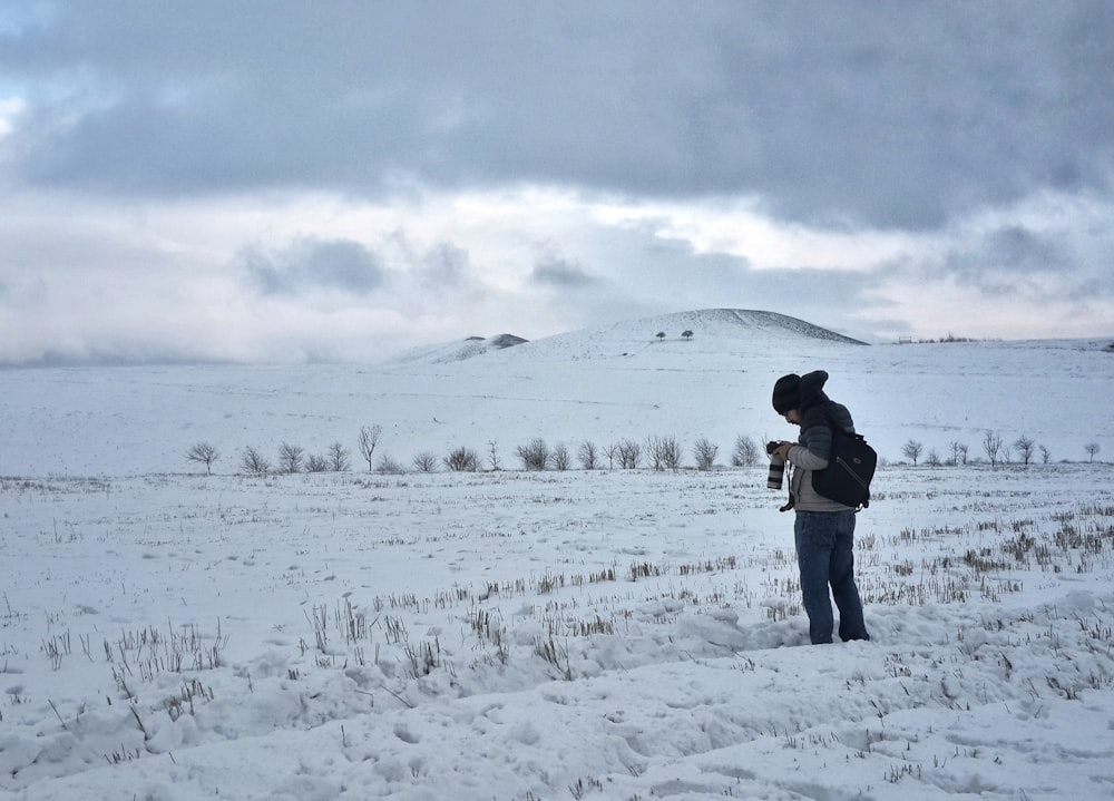 una persona in piedi nella neve con un cane