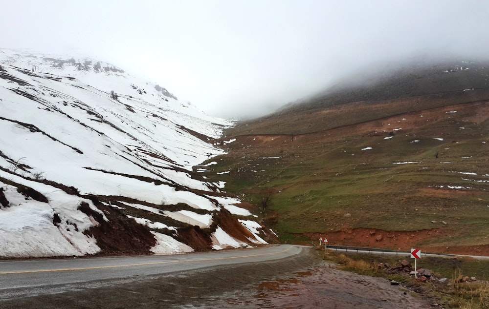 a snow covered mountain with a road going through it