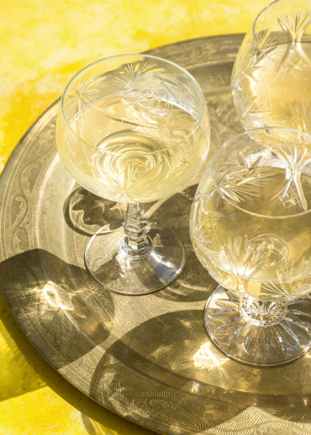three wine glasses sitting on top of a metal tray