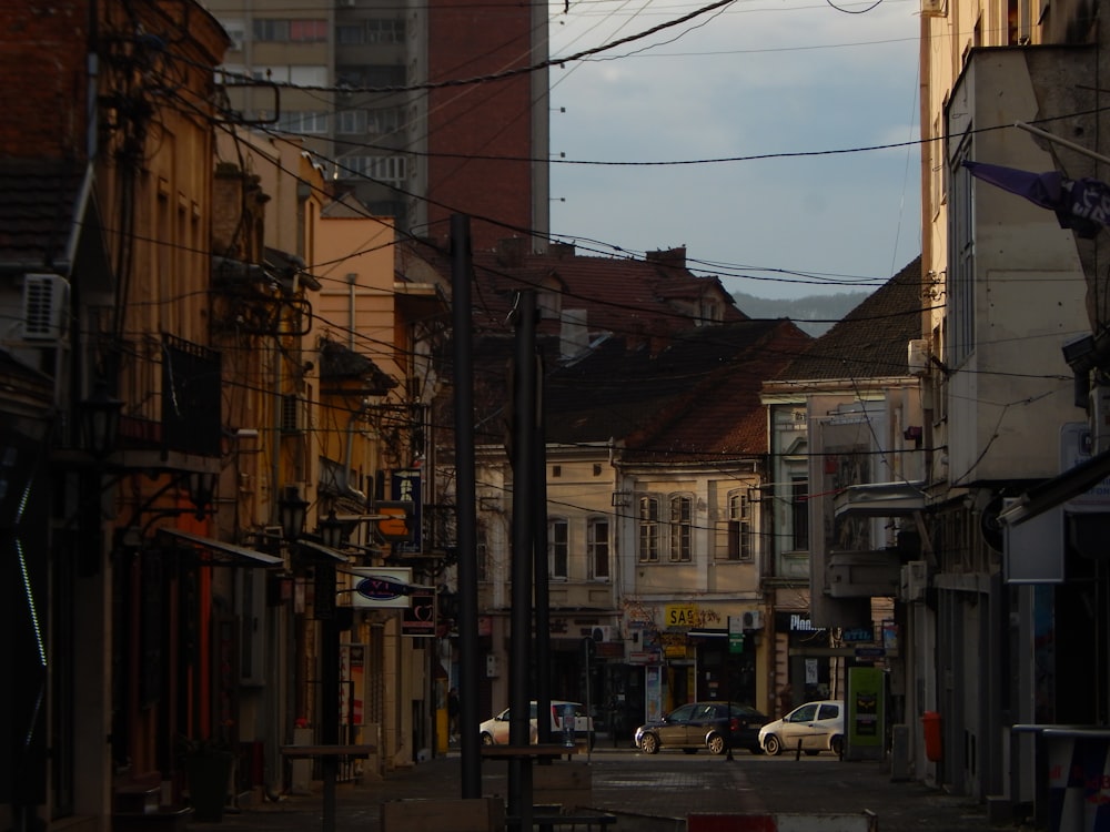 Una calle de la ciudad bordeada de edificios altos y líneas eléctricas