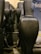 Rows of dark-colored motion seats in a theater or cinema, with a focus on the armrest of one seat in the foreground. The space is dimly lit, creating a cozy and immersive environment.