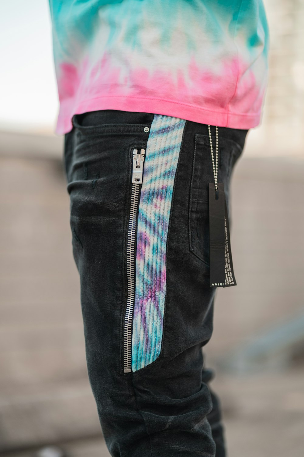 a person wearing a tie dye shirt and jeans