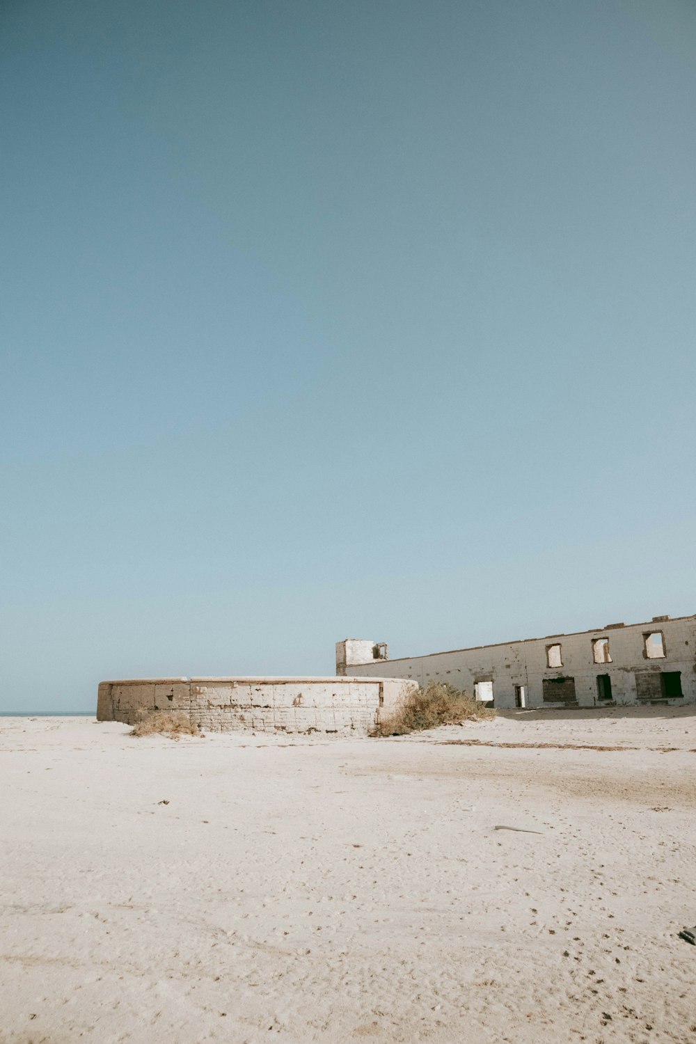 a building sitting on top of a sandy beach