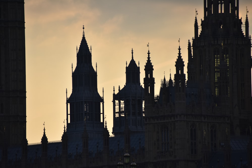 the silhouette of a clock tower against a cloudy sky