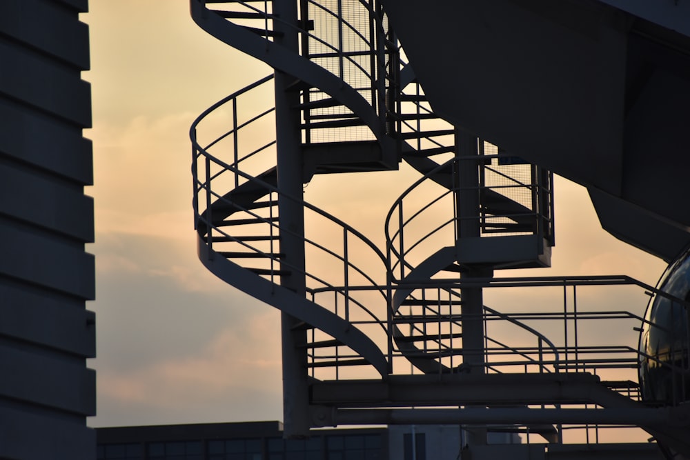 a metal spiral staircase next to a building