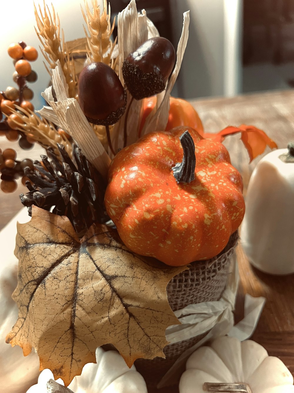a decorative arrangement of fall leaves, acorns, and pumpkins
