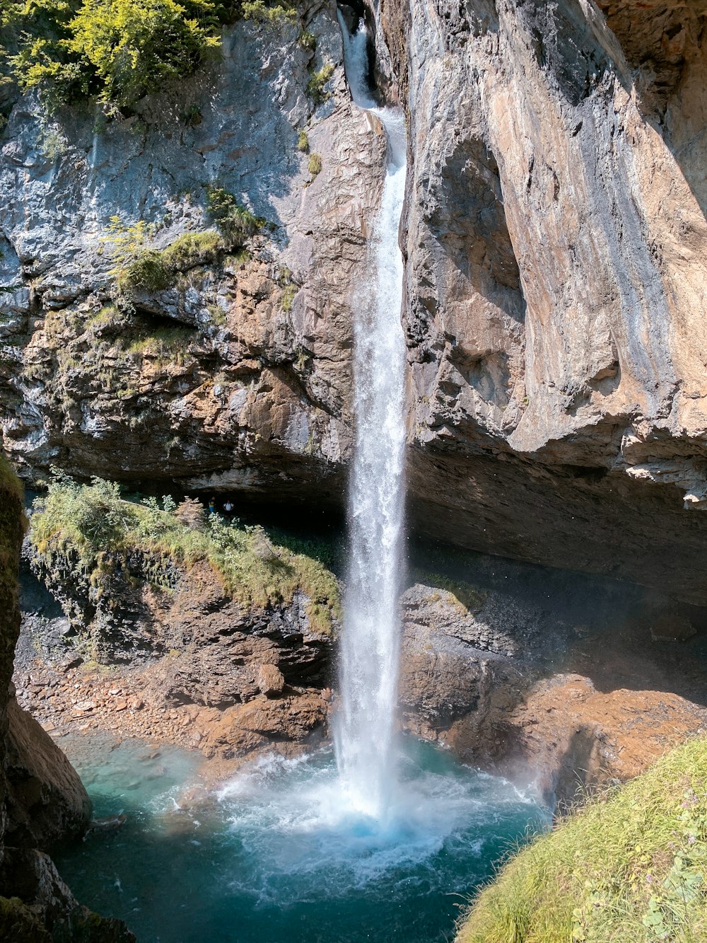 a waterfall is coming out of the side of a cliff