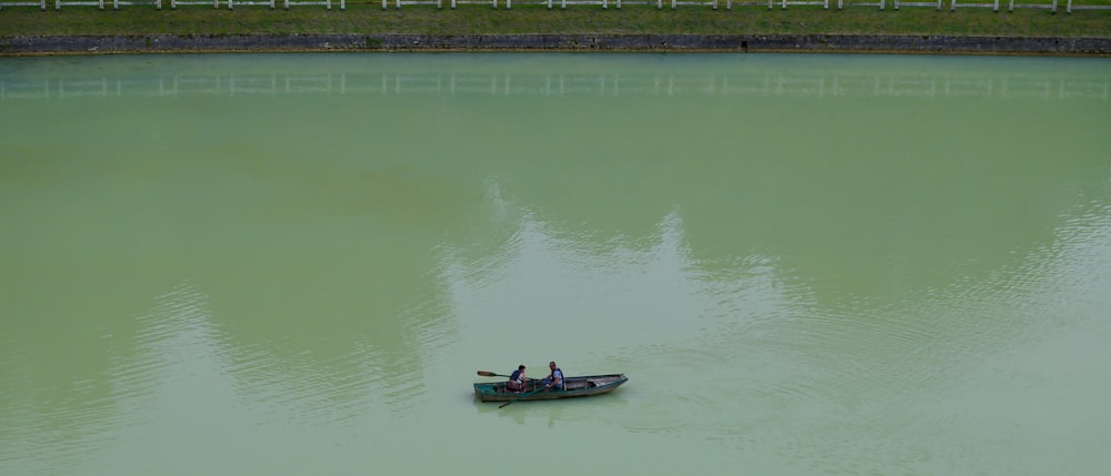 two people in a small boat on a lake