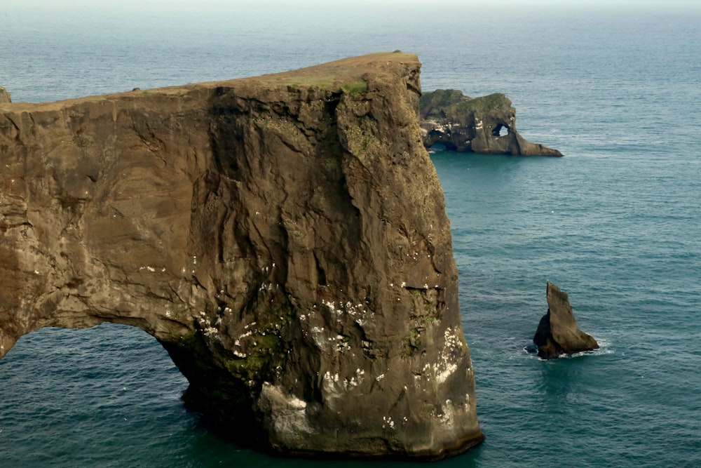 a large rock formation in the middle of the ocean