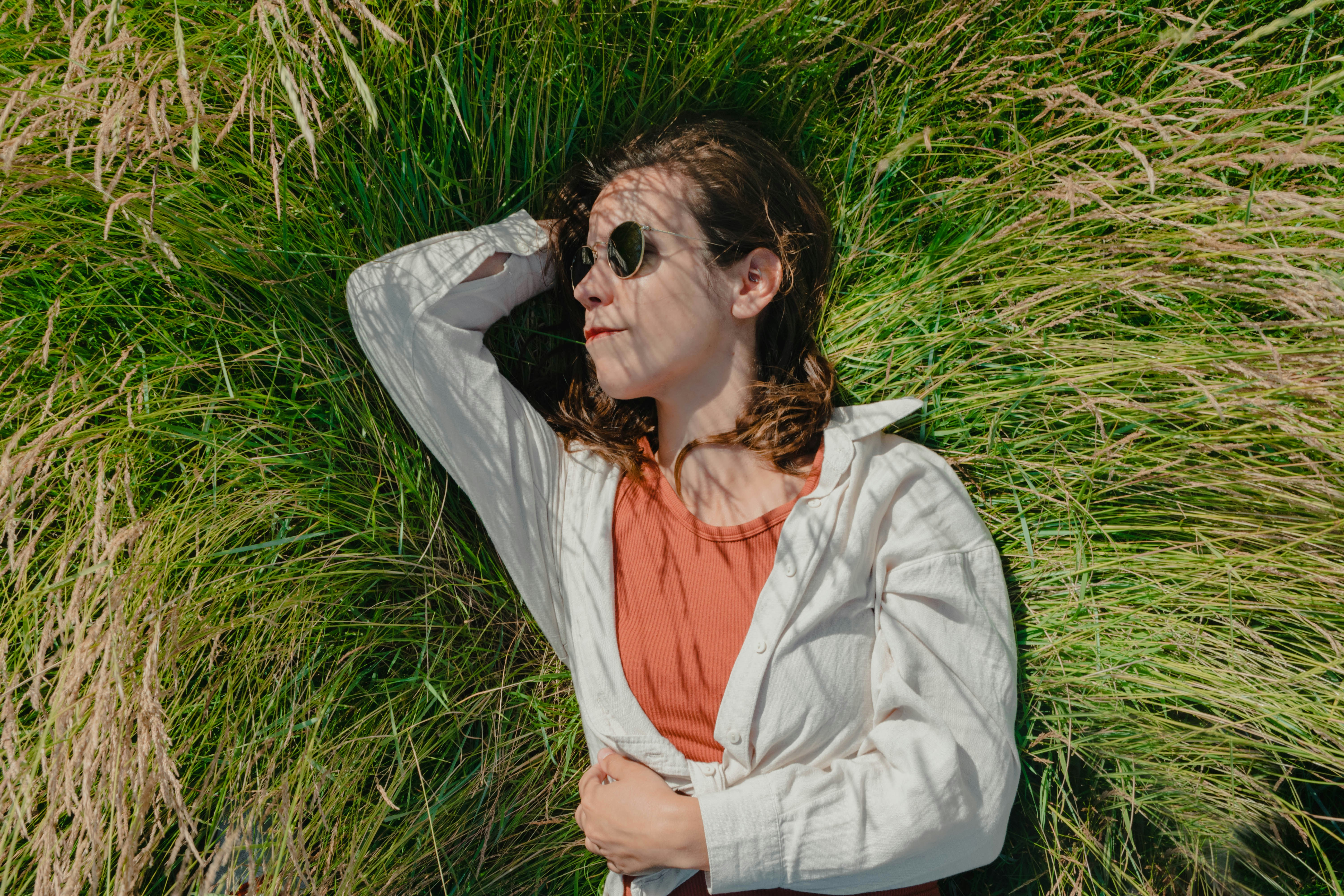 a woman laying in a field of tall grass