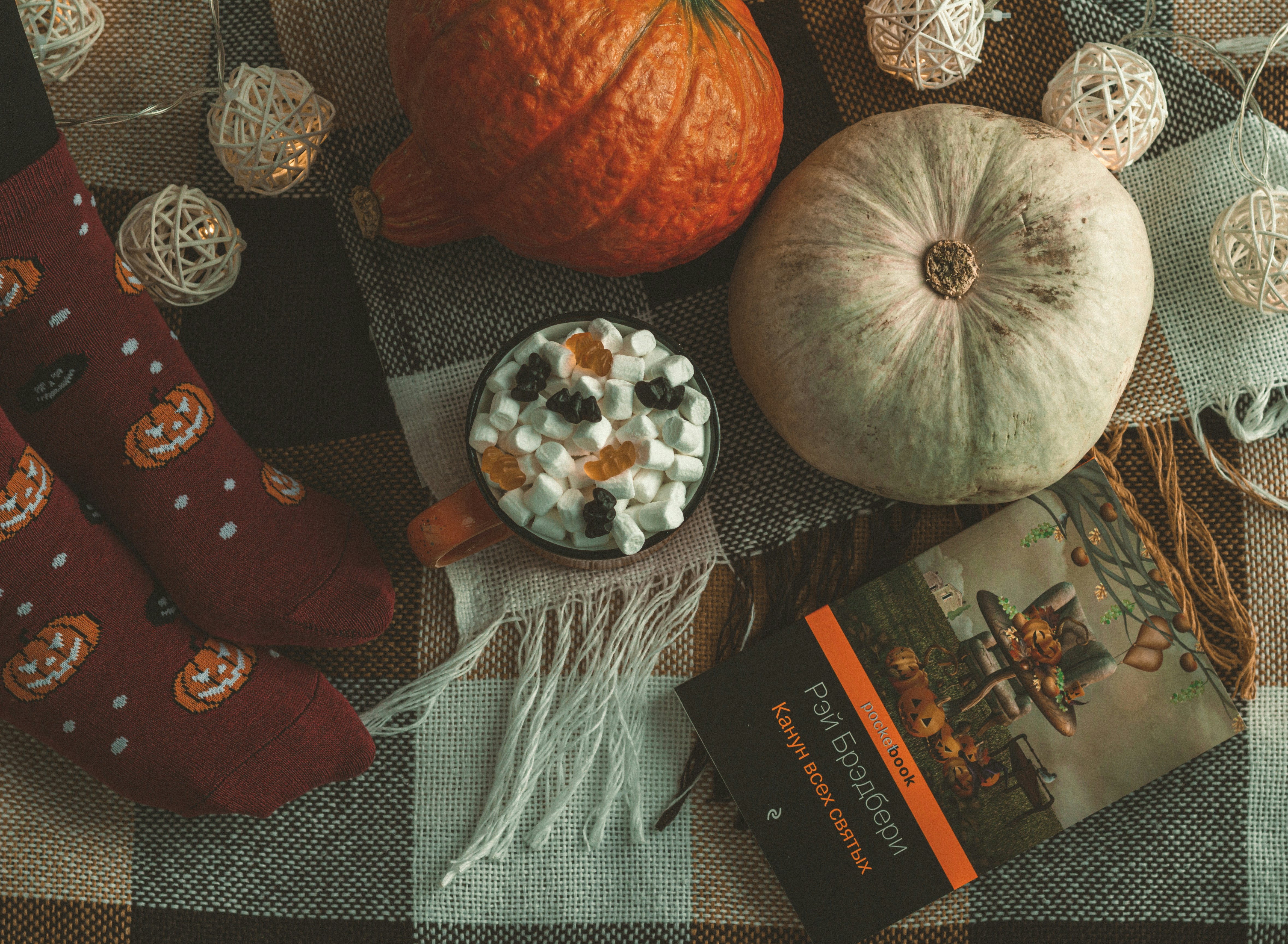 a table topped with pumpkins, marshmallows and a book