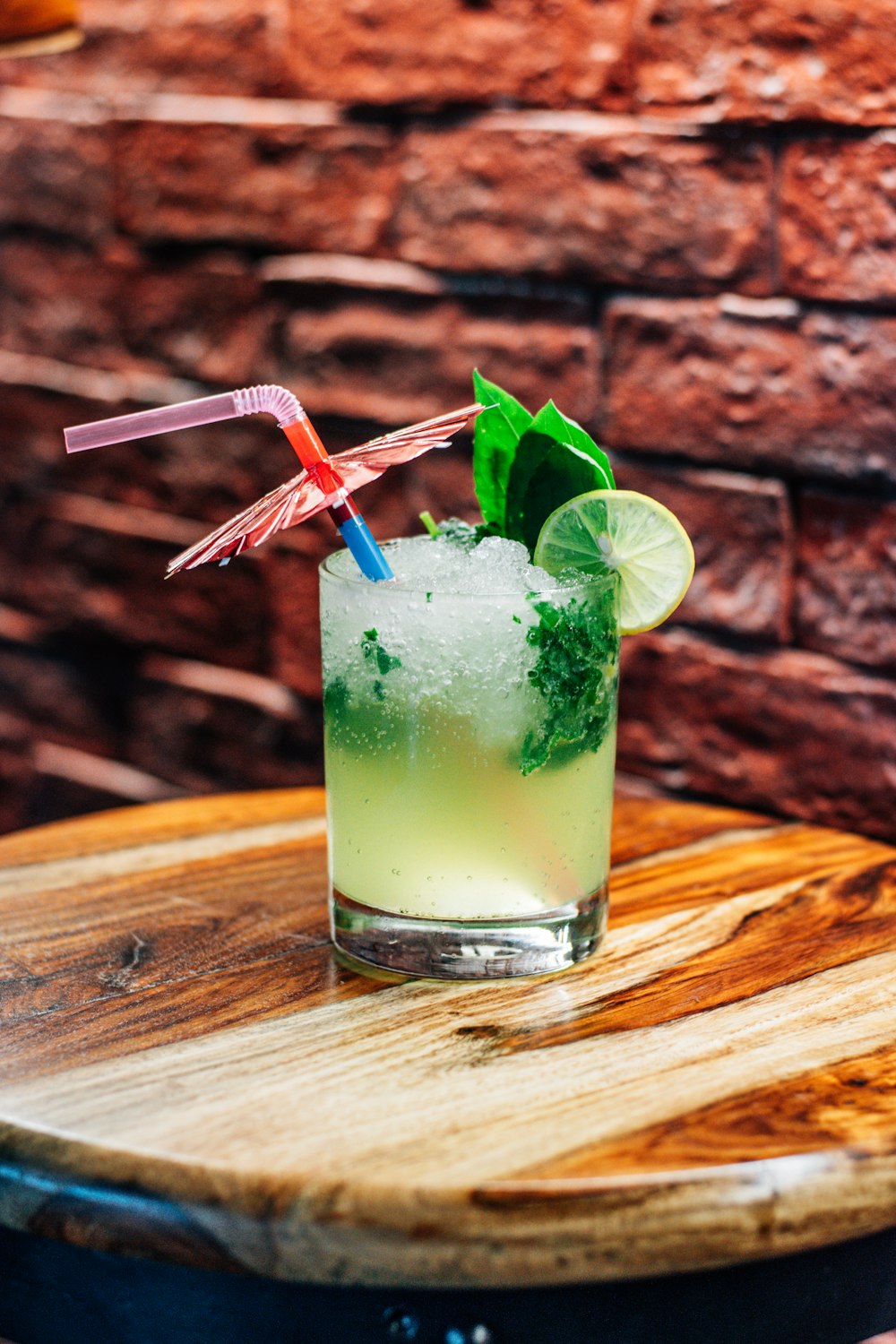 a glass with a green drink and two straws