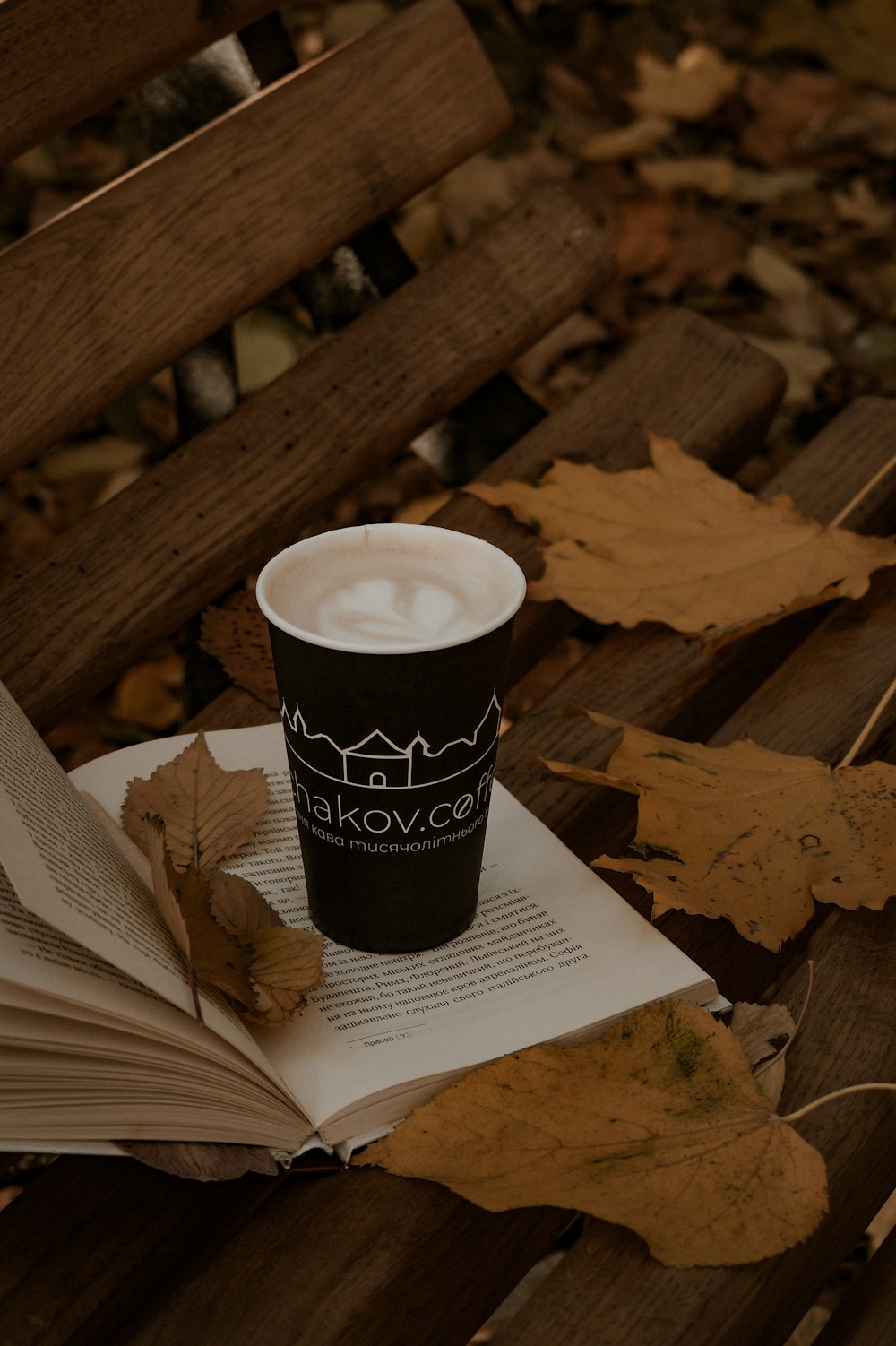 a cup of coffee sitting on top of an open book