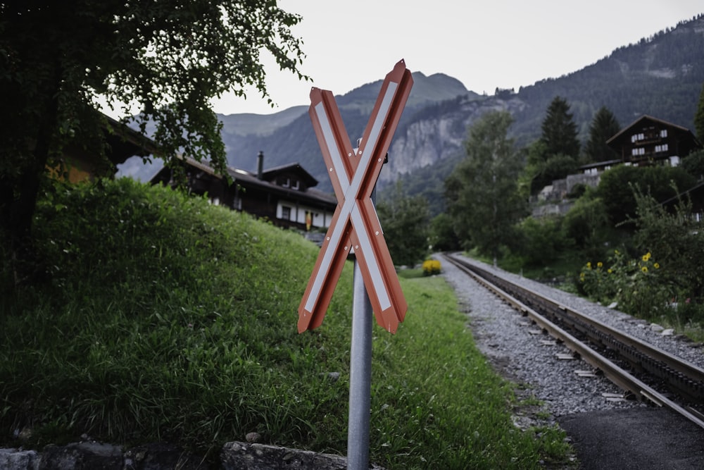 a railroad crossing sign sitting on the side of a train track