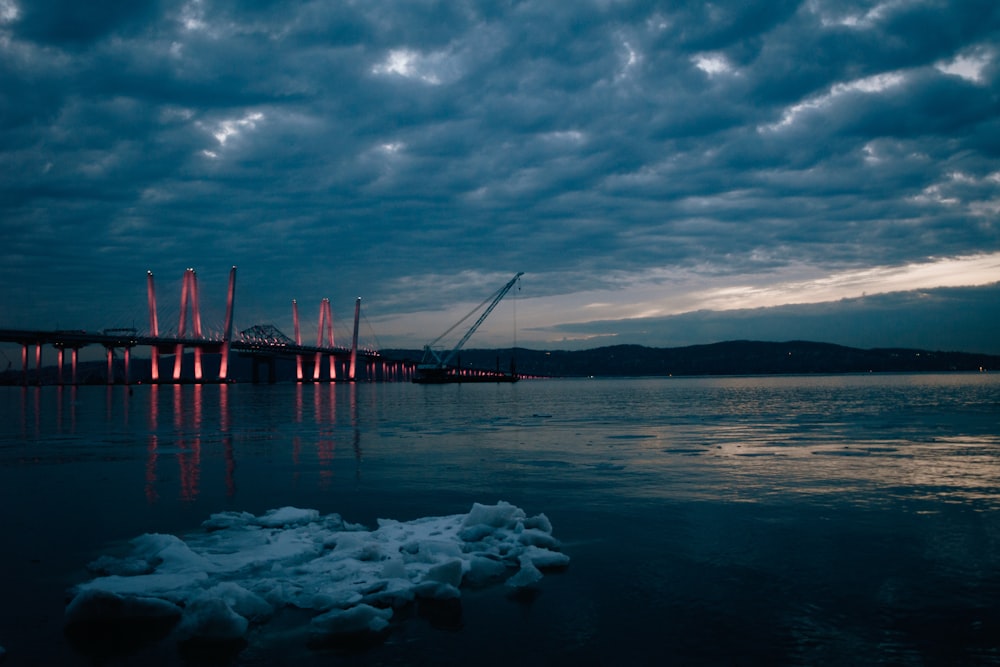 a large bridge over a body of water under a cloudy sky