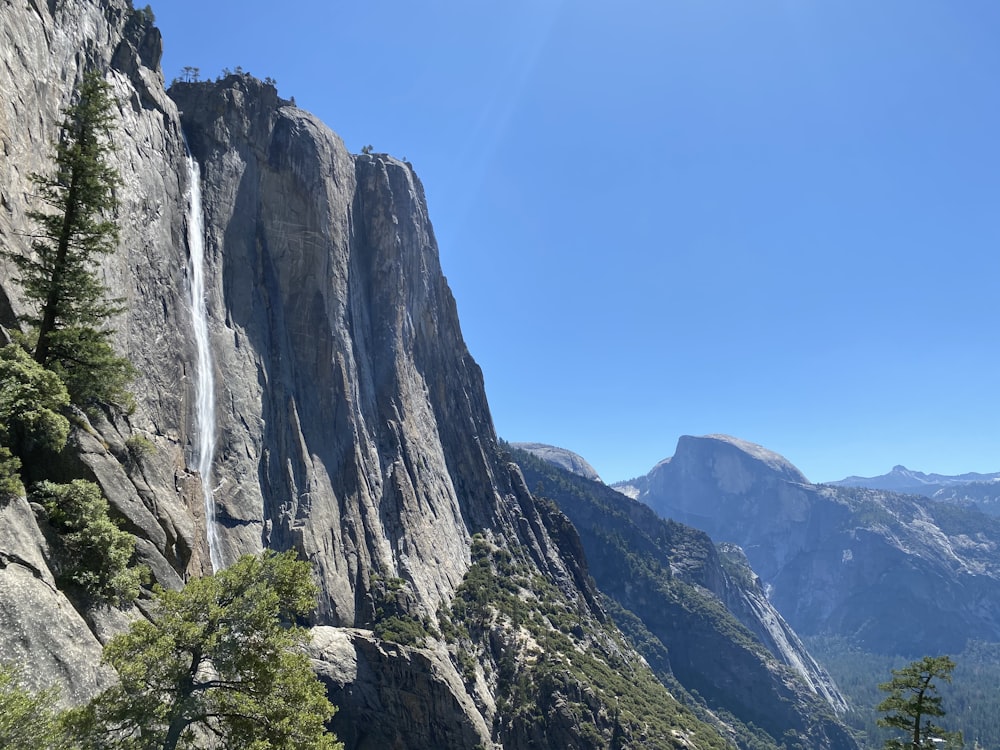 a tall mountain with a waterfall running down it's side