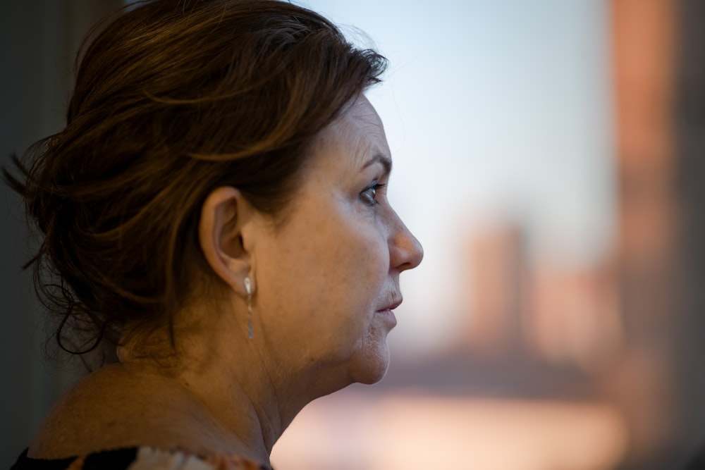 a close up of a person with a city in the background