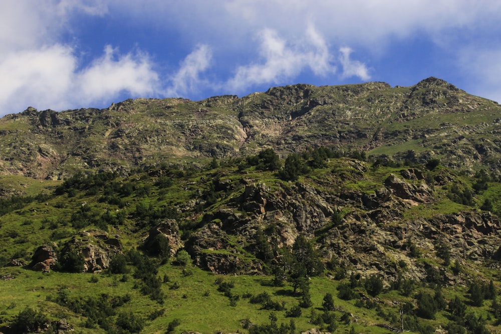 a large mountain with a lush green hillside