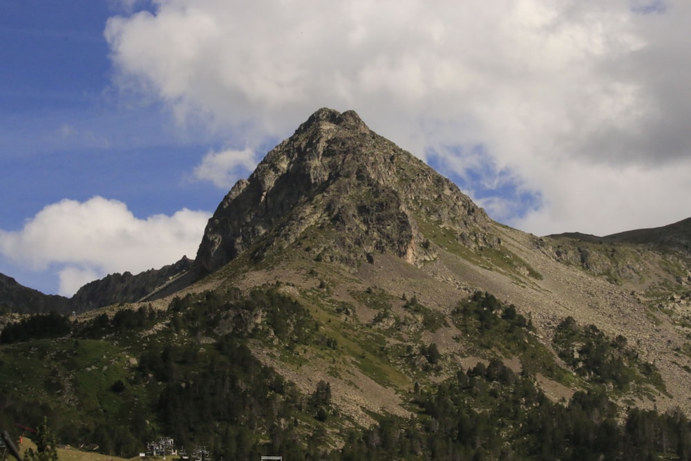 a very tall mountain with some clouds in the sky