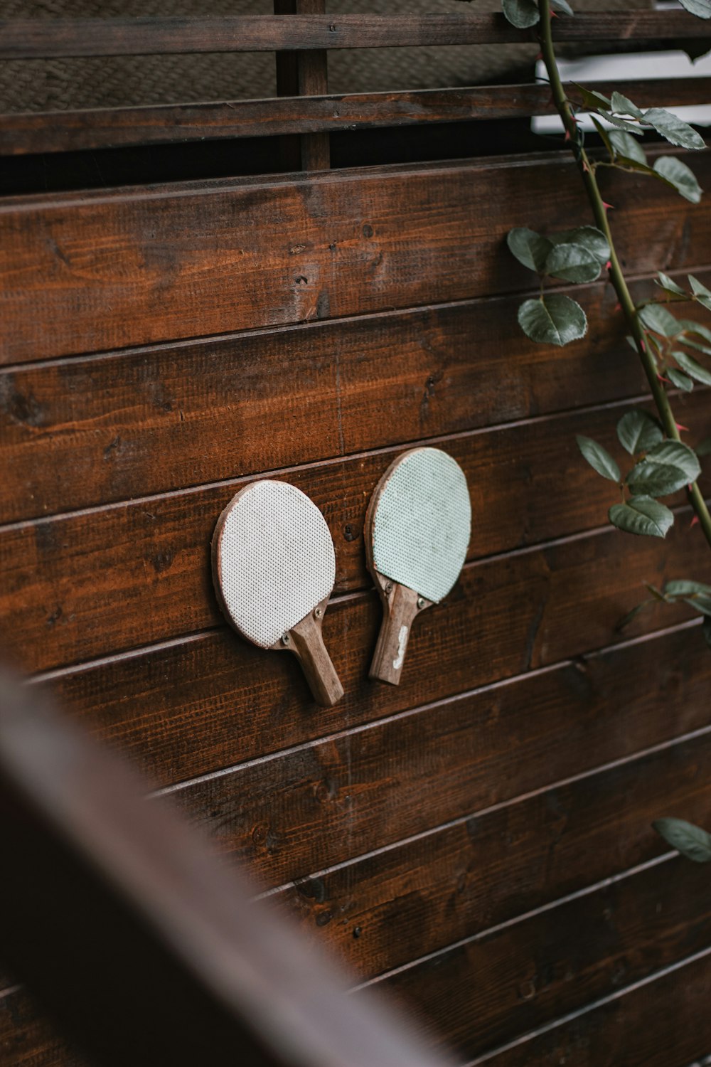 two ping pong paddles on a wooden table