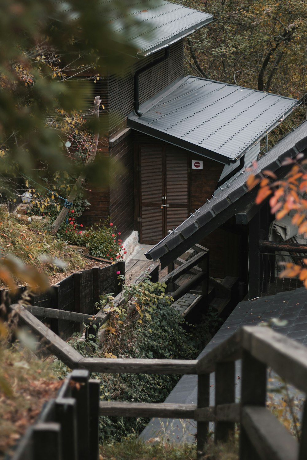 a wooden cabin with a metal roof in the woods